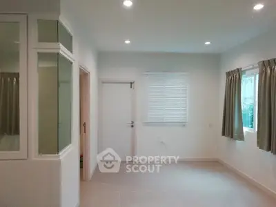 Spacious empty room with large windows and modern lighting, perfect for customization.