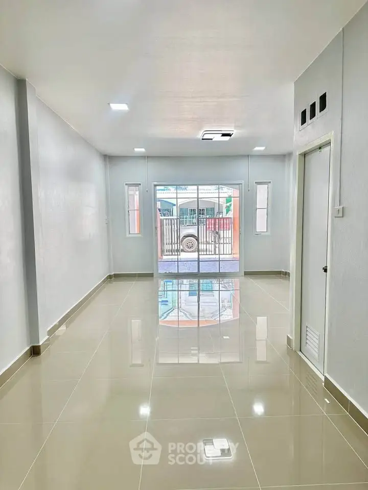 Spacious modern living room with glossy tiled floors and large windows