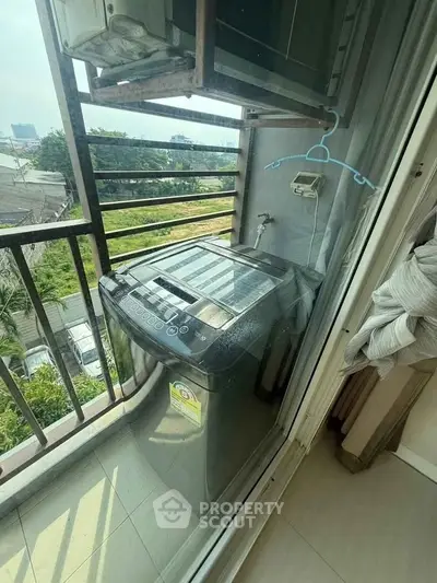 Compact balcony with washing machine and scenic view, ideal for urban living.