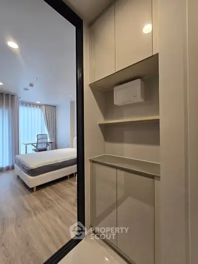 Modern bedroom with sleek storage and natural light, ideal for urban living.