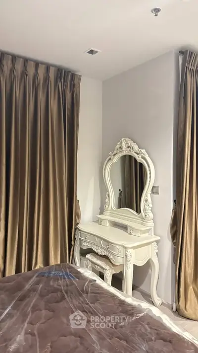Elegant bedroom with luxurious drapes and vintage-style vanity mirror