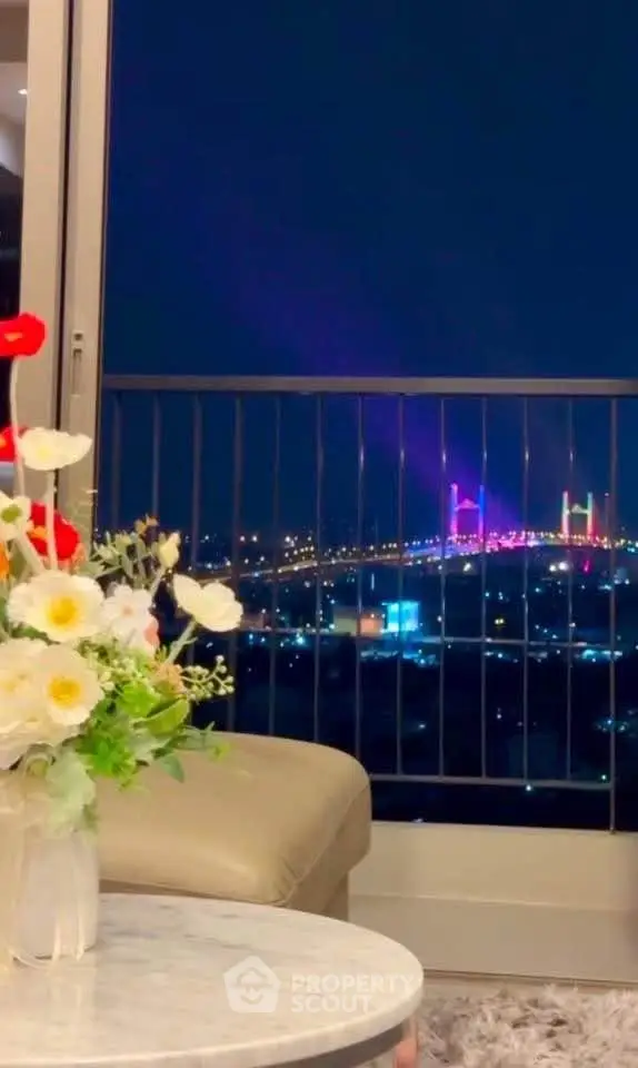 Stunning night view from a luxurious apartment balcony overlooking a beautifully lit bridge.