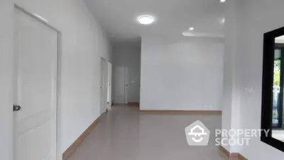 Spacious empty room with glossy tiled flooring and white walls, ideal for customization.