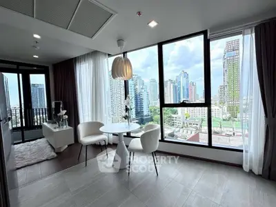 Modern living room with city view, featuring elegant furniture and large windows in a high-rise apartment.