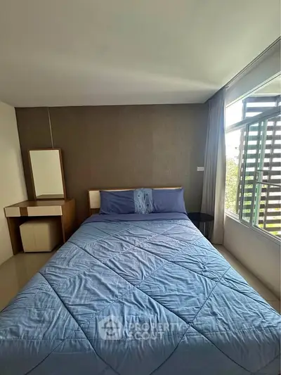 Cozy bedroom with large window and modern decor in a stylish apartment.