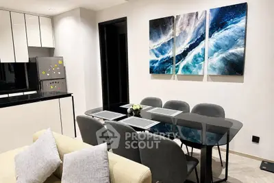 Modern dining area with sleek black table, stylish chairs, and contemporary kitchen in open layout.