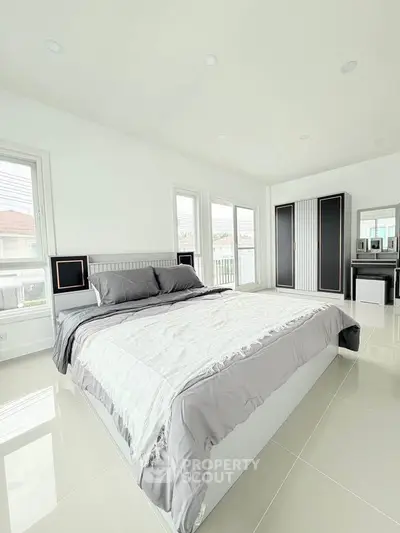 Spacious modern bedroom with large windows and sleek furnishings