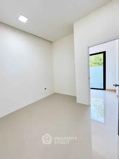 Spacious empty room with glossy tiled floor and natural light