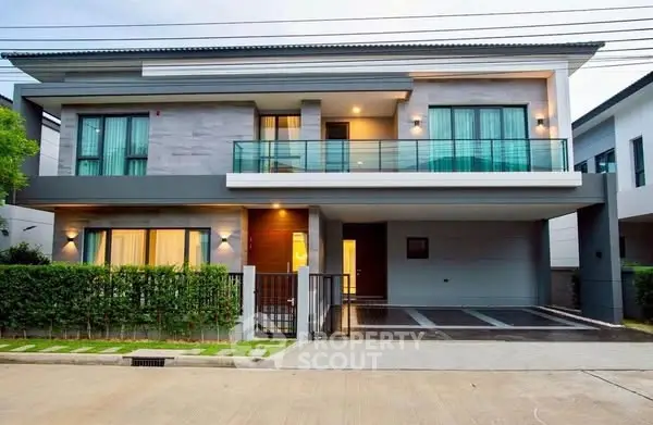 Modern two-story house with spacious driveway and balcony in suburban neighborhood.