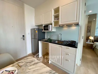 Modern compact kitchen with sleek cabinetry and dining area in stylish apartment
