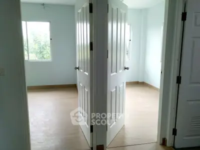 Spacious interior with light wood flooring and white doors, perfect for modern living.