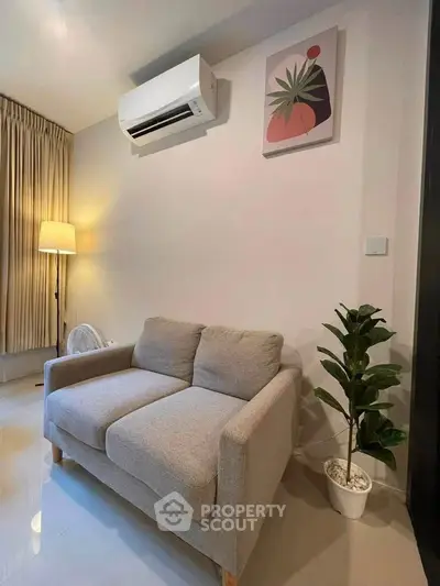 Cozy living room with modern sofa, air conditioning, and stylish decor.