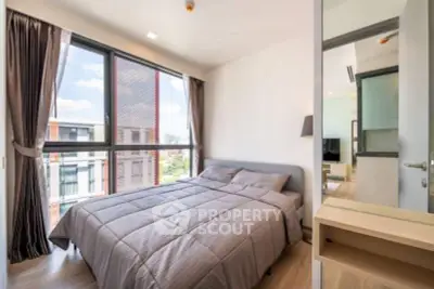Modern bedroom with large windows and city view in a stylish apartment.