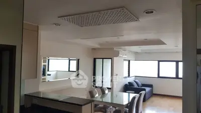Spacious modern living room with dining area and large windows for natural light.