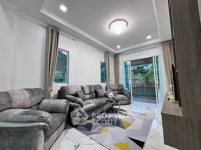 Luxurious living room with plush sofas and elegant decor, featuring large windows and a stylish chandelier.