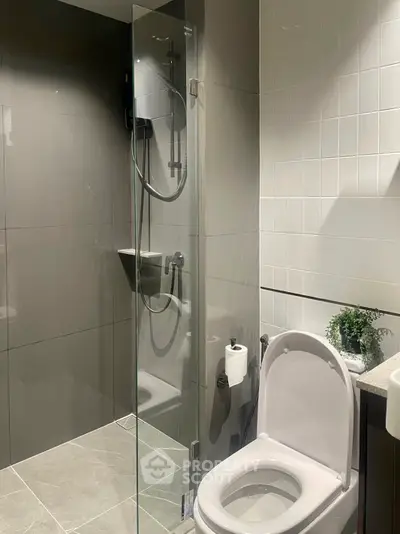 Modern bathroom with sleek shower and elegant fixtures in contemporary apartment.