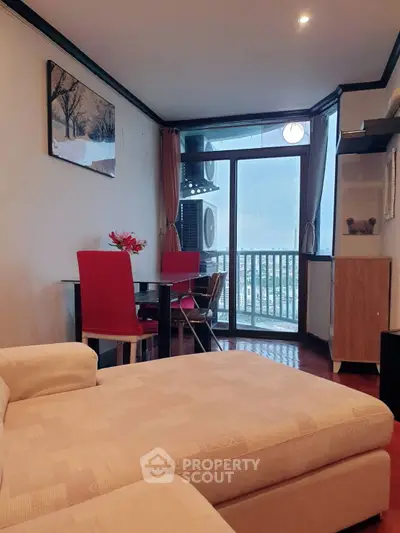 Charming living room with cozy sofa and dining area, featuring a balcony with city view.