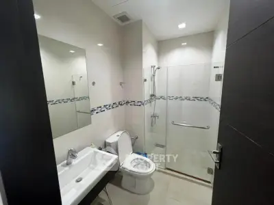 Modern bathroom with glass shower and sleek fixtures in a contemporary home.