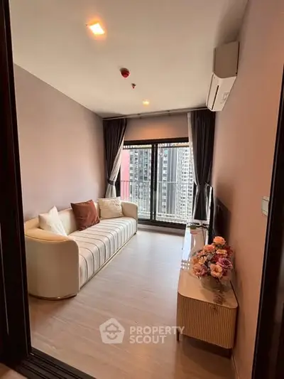 Modern living room with city view, stylish sofa, and elegant decor in high-rise apartment.