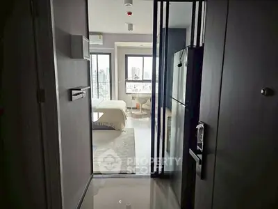 Modern apartment entrance with view into a stylish bedroom and cityscape beyond.