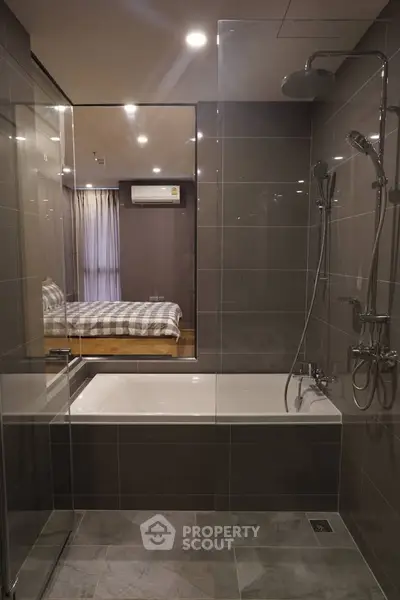Modern bathroom with glass shower and bathtub in stylish apartment