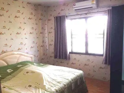 Cozy bedroom with patterned wallpaper and natural light from window