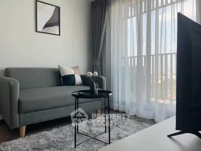 Modern living room with stylish sofa, elegant decor, and large window offering natural light.