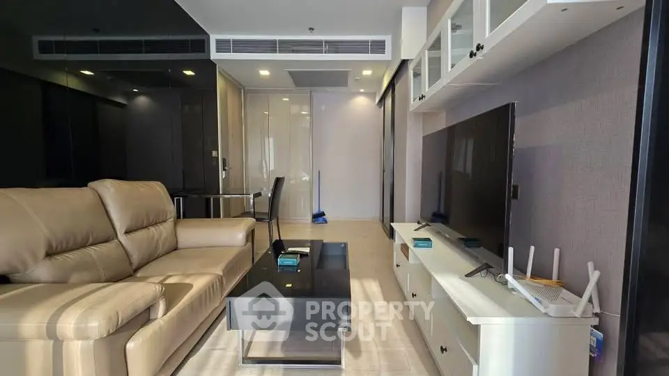 Modern living room with leather sofa and large TV in stylish apartment