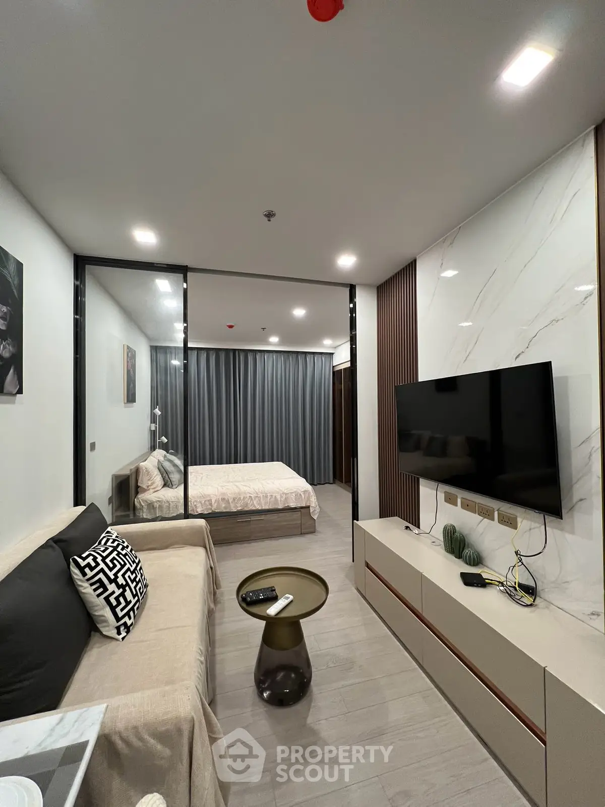 Modern studio apartment with stylish decor, featuring a cozy living area and a comfortable bed.
