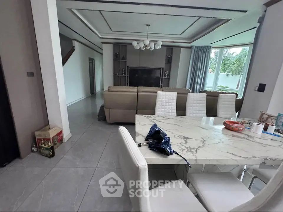 Spacious modern living room with elegant marble dining table and large windows