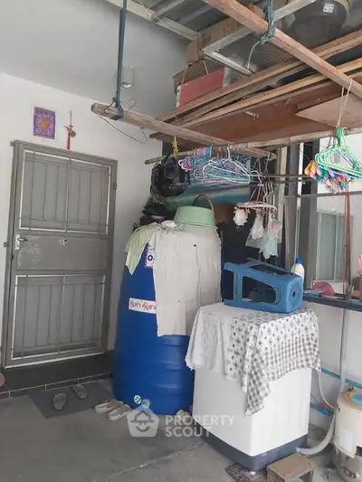 Functional storage area with washing machine and water tank, ideal for practical home organization.