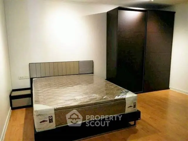 Spacious bedroom with modern design and ample storage in a stylish apartment.