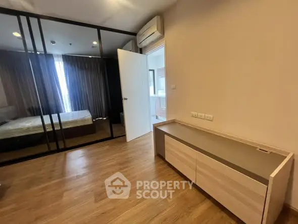 Modern bedroom with wooden flooring and mirrored closet doors