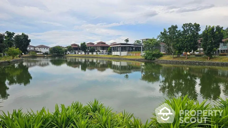 Stunning lakeside view with modern homes and lush greenery, perfect for serene living.