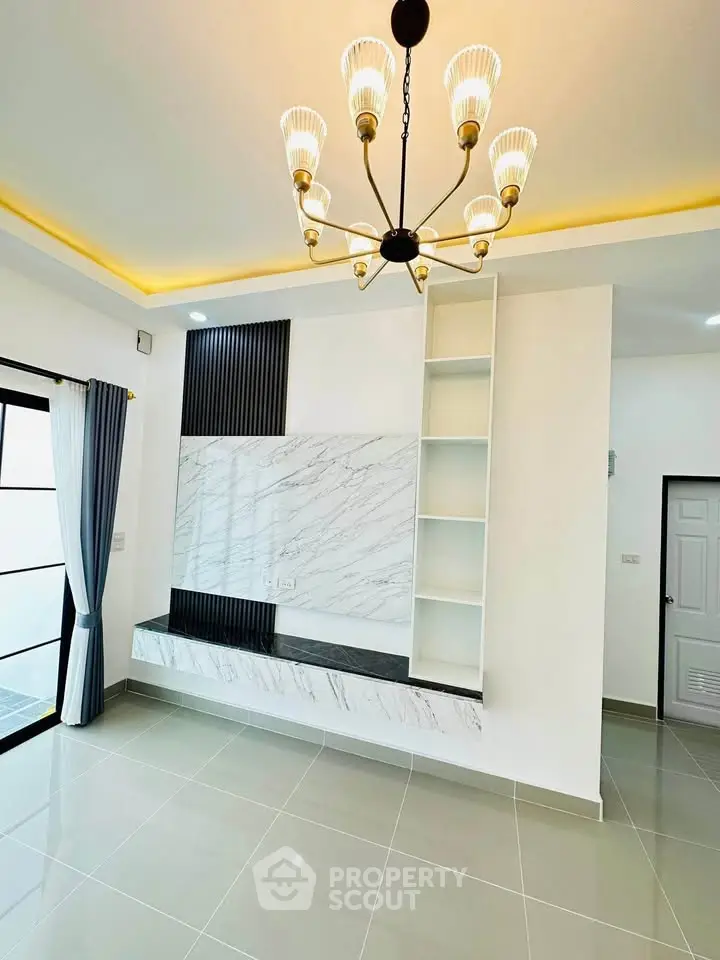 Modern living room with elegant chandelier and marble accent wall
