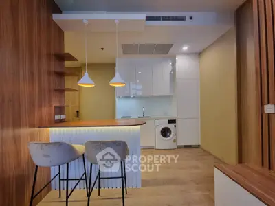 Modern kitchen with sleek design, featuring a washing machine and stylish lighting, perfect for urban living.