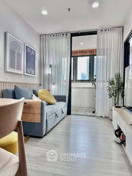 Modern living room with stylish decor and large window view in urban apartment.