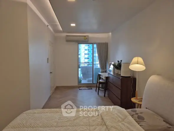 Spacious bedroom with balcony view and modern furnishings