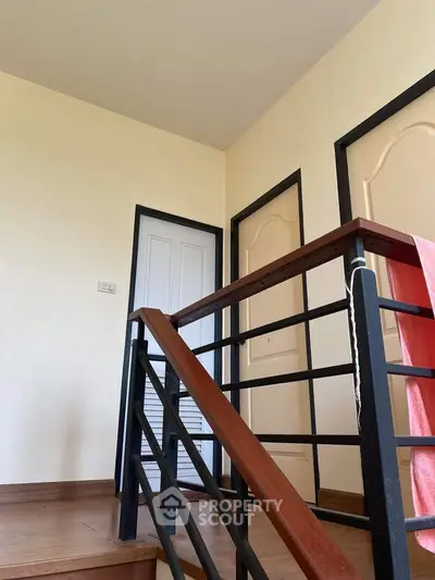 Modern interior staircase with wooden steps and metal railing in a contemporary home.