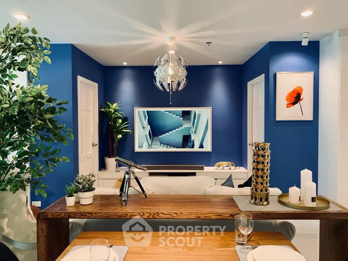 Modern living room with stylish decor, blue accent wall, and elegant dining setup.