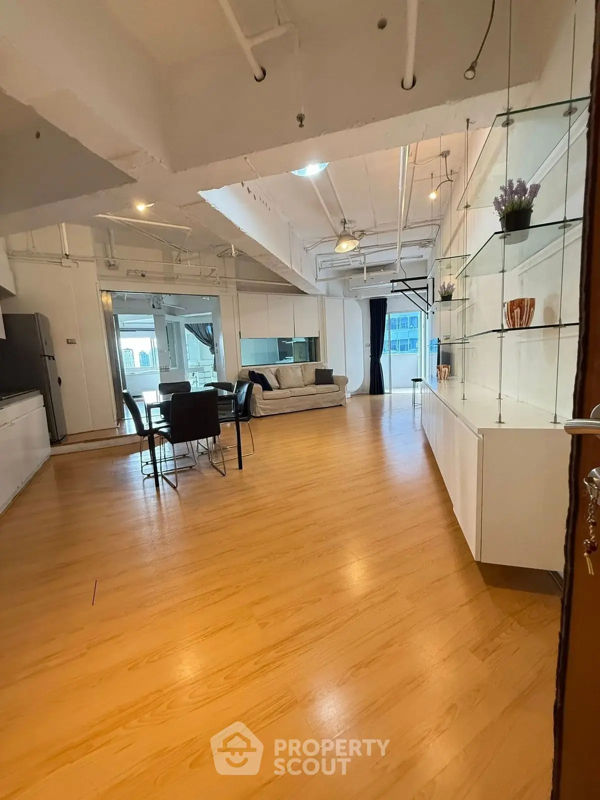 Spacious open-plan living room with modern decor and wooden flooring