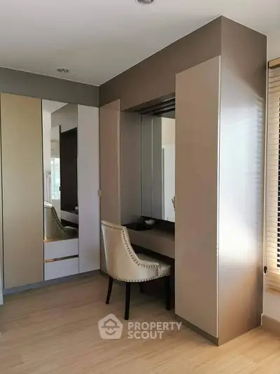 Elegant bedroom corner with built-in wardrobe and stylish chair, perfect for modern living.