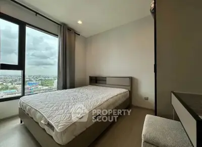 Modern bedroom with large window offering stunning city views