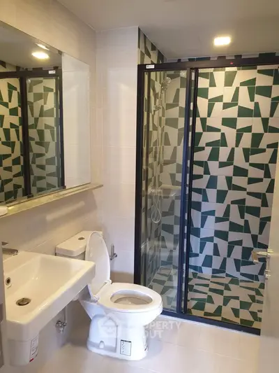 Modern bathroom with geometric tile shower and sleek fixtures