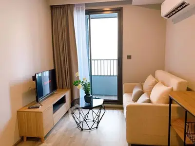 Modern living room with cozy sofa, TV, and balcony access in stylish apartment.