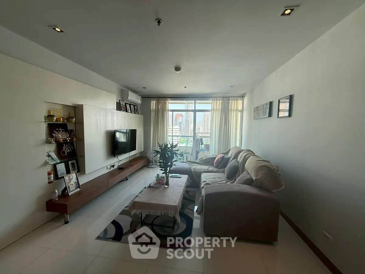 Spacious living room with modern decor and city view, perfect for relaxation and entertainment.