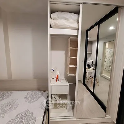 Modern bedroom with sliding wardrobe and mirrored doors, showcasing stylish interior design.