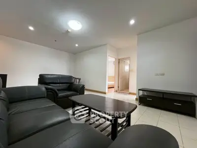 Spacious living room with modern black leather furniture and open layout