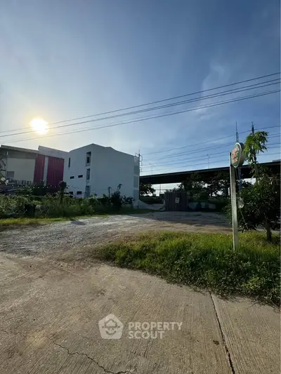 Modern building exterior with lush greenery and clear blue sky, ideal for serene living.
