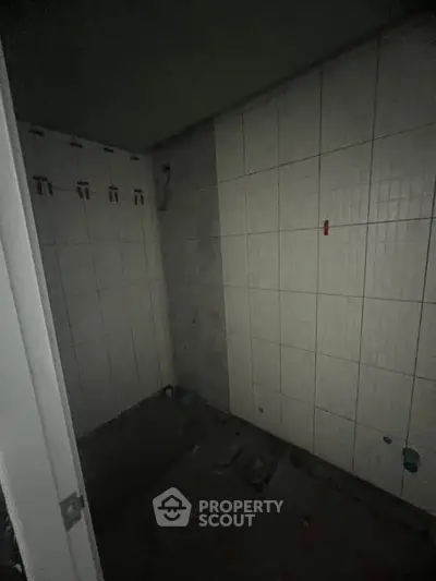 Under-construction bathroom with tiled walls and unfinished flooring.